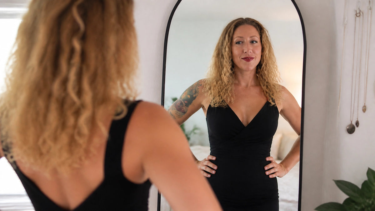 Photorealistic image of Sherry Martin standing confidently before her reflection in a tailored black dress