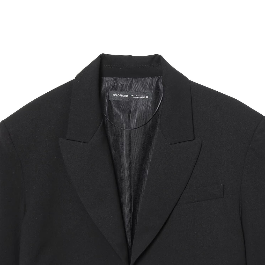 Black short suit jacket with shoulder pads and pleats